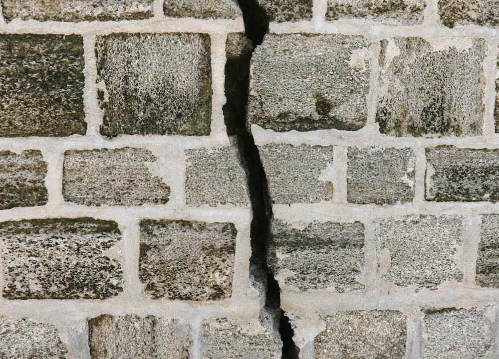 Fissure verticale traversant un mur en blocs maçonnés